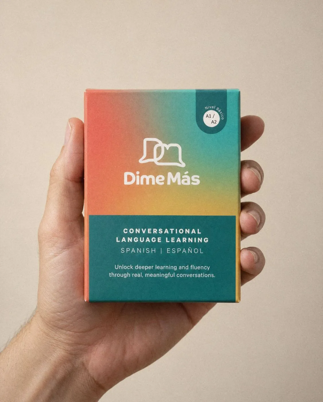 A hand holding the Dime Más Cards beginner box