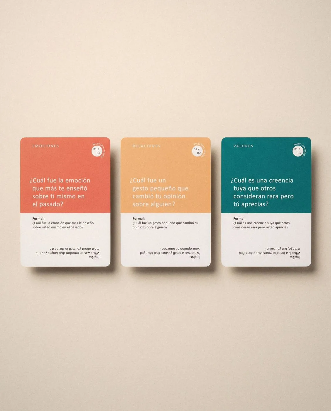 Three Dime Más question cards, Spanish with English beneath.